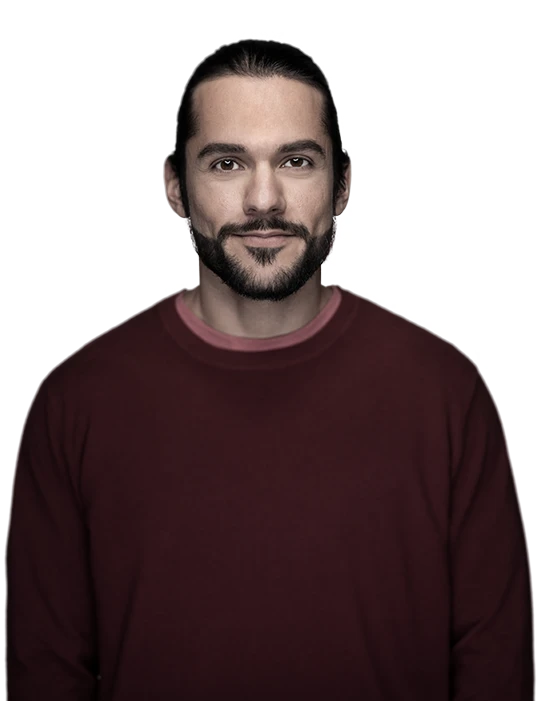 Ung man med lite skägg tittar rakt in i kameran