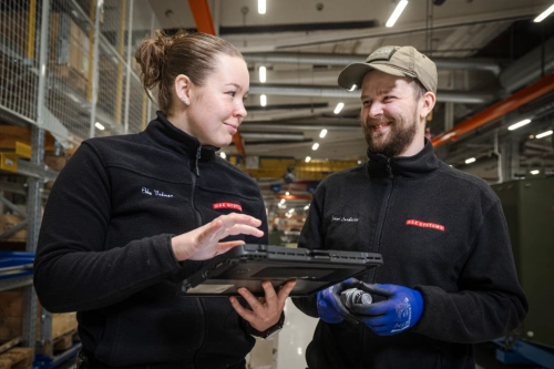 En kvinnlig och en manlig medarbetare på BAE Systems Hägglunds pratar leende med varandra